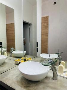 Baño con 3 lavabos en una encimera con espejo en Casa Simona en Las Rabonas
