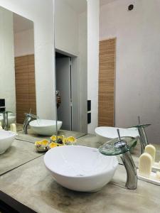a bathroom with three sinks on a counter with a mirror at Casa Simona in Las Rabonas