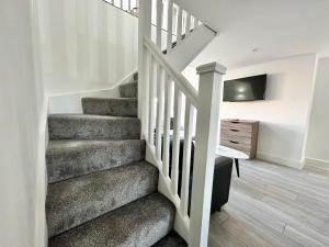 a staircase in a home with a television and a stair case at Luxury Duplex City Centre Apartment in Leeds
