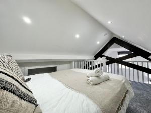 a bedroom with a bed with a towel on it at Luxury Duplex City Centre Apartment in Leeds