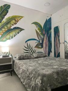 um quarto com uma cama com um mural na parede em Baku Laureles Hostel em Medellín