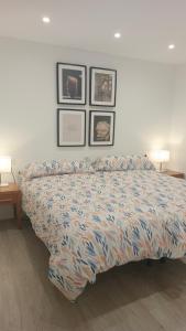 1 cama en un dormitorio con 3 cuadros en la pared en Apartamento Tajinaste con vistas al mar y la montaña y wifi gratis, en Los Realejos