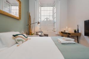 een slaapkamer met een groot wit bed en een spiegel bij C60 Pretty loft in downtown in Málaga