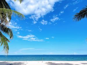 a beach with two palm trees and the ocean at Talay Sai @ Thung Wua Laen in Pathiu