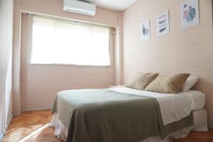 una camera da letto con un grande letto e una finestra di M Pugliese Amplio, cómodo y luminoso a metros del subte a Buenos Aires