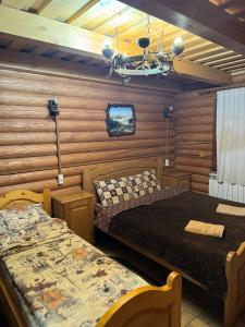 a bedroom with two beds and a chandelier at Садиба MISHEL in Yablunytsya