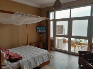 La Villa d'O في توباب ديالاو: غرفة نوم بسرير ونافذة كبيرة