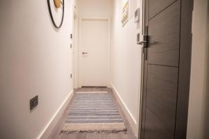 a hallway with a door and a rug at Kirkgate Suites - Majestic City Centre Apartment in Leeds