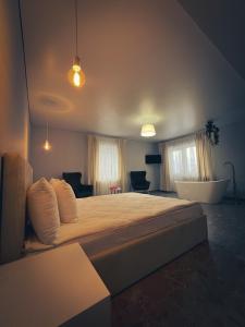 a large bedroom with a large bed and a tub at Imperial Hotel in Bukovel