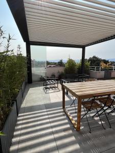エヴィアン・レ・バンにあるIMMODREAMS - L'Attik with lake views and 80m2 terraceの屋上のパティオ(テーブル、椅子付)
