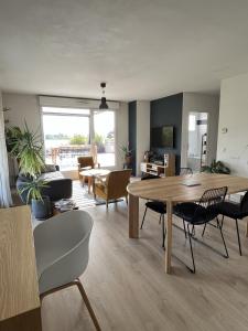 duży salon ze stołem i krzesłami w obiekcie IMMODREAMS - L'Attik with lake views and 80m2 terrace w mieście Évian-les-Bains