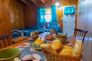 a table with a basket of bread on it at Mi Sueño Bed and Breakfast in Aluminé
