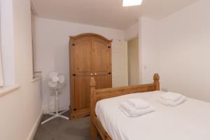 - une chambre avec un lit et une armoire en bois dans l'établissement Cosy 2BR Apartment in Nottingham, à Nottingham