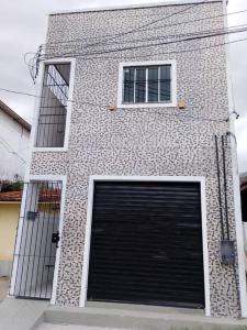 een gebouw met twee garagedeuren en twee ramen bij Apartamento novo e confortável in Belém