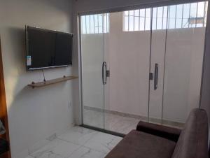 a living room with a sliding glass door with a tv at Apartamento novo e confortável in Belém