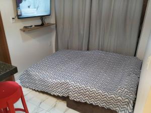 a small bedroom with a bed and a television at Apartamento novo e confortável in Belém