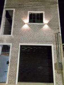 a brick building with a parking garage and two windows at Apartamento novo e confortável in Belém