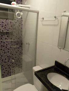 y baño con ducha, aseo y lavamanos. en Apartamento novo e confortável en Belém