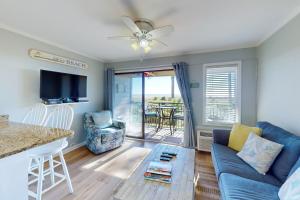 - un salon avec un canapé bleu et une table dans l'établissement Sea Side Villas 171, à Île de Hilton-Head