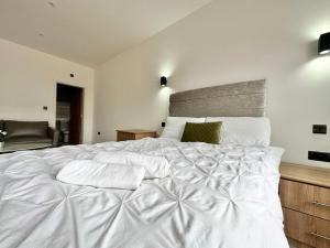 a white bed with two pillows on top of it at Cute, Stylish 1 Bedroom Leeds City Apartment in Leeds