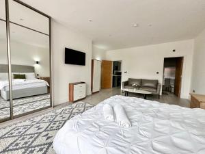 ein Schlafzimmer mit einem großen weißen Bett und einem Spiegel in der Unterkunft Cute, Stylish 1 Bedroom Leeds City Apartment in Leeds