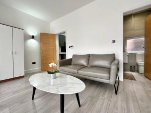 ein Wohnzimmer mit einem Sofa und einem Tisch in der Unterkunft Cute, Stylish 1 Bedroom Leeds City Apartment in Leeds