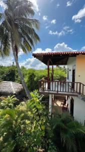 a house with a deck and a palm tree at The lookout lodge in Tangalle
