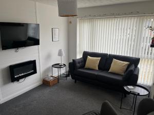 a living room with a couch and a television at Bee Bungalow in Blackpool in Blackpool