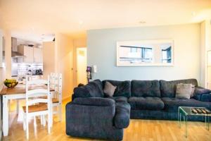 a living room with a blue couch and a table at Modern 2-Bed Flat with Breathtaking City Views in Leeds