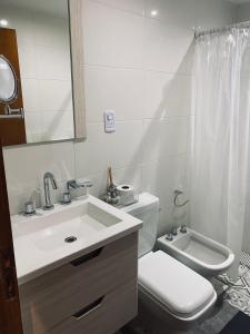 y baño con lavabo, aseo y espejo. en Cabañas Golden en San Rafael