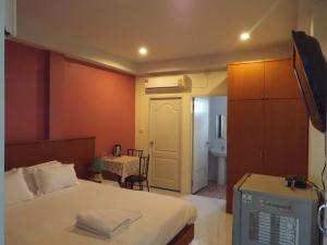 um quarto com uma cama e uma mesa e um quarto em Grandma Kaew House em Chiang Rai