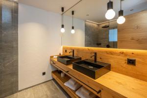 a bathroom with two sinks and a mirror at Mountain Lodge in Grächen