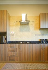 uma cozinha com armários de madeira e um forno com placa de fogão em Westwood Residences em Arusha
