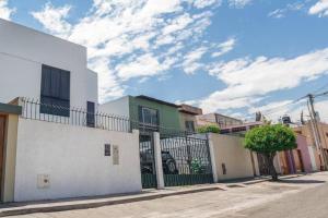 ein weißes Gebäude mit einem Tor auf einer Straße in der Unterkunft Villa Arequipa in Arequipa