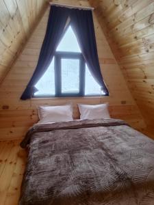 1 dormitorio con 1 cama grande y ventana en Gold Star en Kazbegi