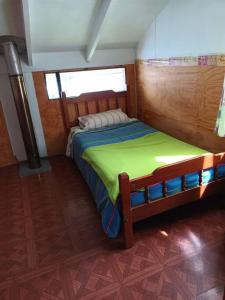 a small bedroom with a bed in a room at Cabaña a metros de la playa San Ignacio, Niebla in Valdivia