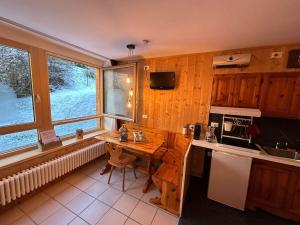 a kitchen with a wooden table and a counter top at La Baipa Accesso piste in Mezzana