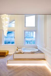 ein Schlafzimmer mit einem großen Bett in einem Zimmer mit Fenstern in der Unterkunft JACUZZI ROYAL SUITE in Budapest