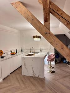 eine Küche mit weißen Arbeitsflächen und einer Holzdecke in der Unterkunft JACUZZI ROYAL SUITE in Budapest