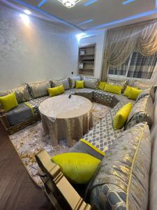 a living room with a large couch and a table at Oujda hay Salam doha in Oujda