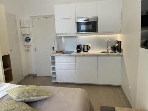 een witte keuken met een spoelbak en een magnetron bij Appartement Vincennes cozy in Vincennes +7 foto's