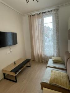 un soggiorno con divano e TV di Appartement Vincennes cozy a Vincennes