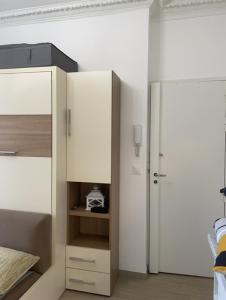 Appartement Vincennes cozy في فينسين: غرفة نوم مع سرير وخزانة بيضاء