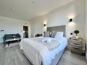 a bedroom with a large white bed and a chair at Sleek Stylish 1 Bedroom Leeds City Apartment in Leeds