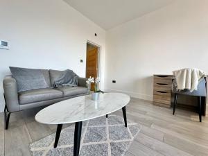 a living room with a couch and a table at Sleek Stylish 1 Bedroom Leeds City Apartment in Leeds