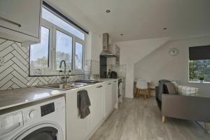 a kitchen with a sink and a washing machine at GuestReady - Comfortable Leeds City Apartment in Kirkstall