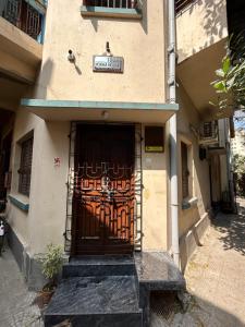 a building with a large door with a metal gate at Teakwood Suite - Nokha House in Kolkata