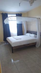 En eller flere senge i et værelse på Nyali cozy home
