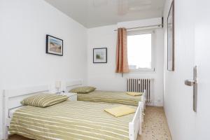 two beds in a white room with a window at Blanc-mesnil superb F3 BATB 1er ETG face in Le Blanc-Mesnil