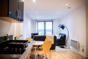 a kitchen and living room with a couch and a table at GuestReady - City Centre Apartment, Sleep 4 in Hunslet